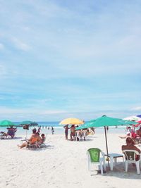 People at beach against sky