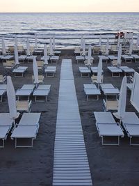 Chairs on beach against sky