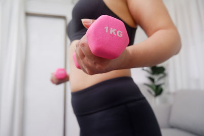 Midsection of woman holding heart shape