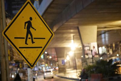 Close-up of arrow sign on road in city