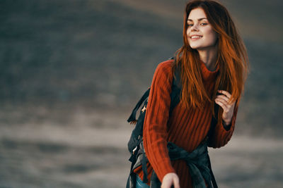 Portrait of smiling young woman standing in winter