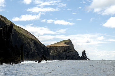 Rock formations by sea against sky