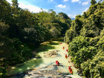 High angle view of people rafting in river against sky