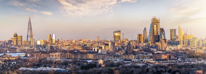 Modern buildings in city against cloudy sky