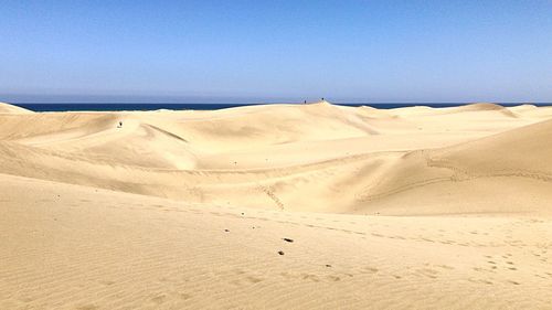 Scenic view of desert against clear blue sky