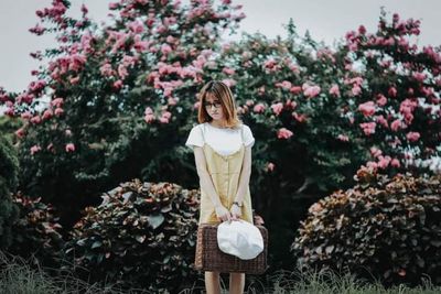 Woman standing by flowering plants