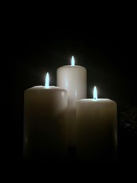 Close-up of illuminated tea light candles in darkroom