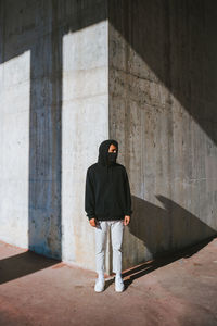 Rear view of man walking on concrete wall