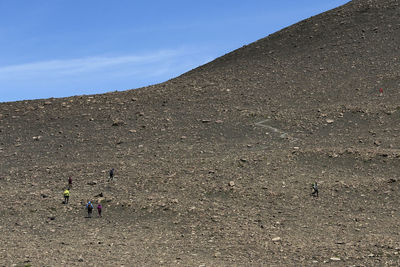 People walking on land against sky