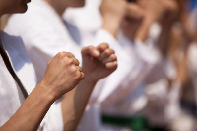 Midsection of people gesturing while practicing karate