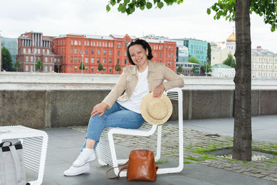 Portrait of smiling young woman sitting outdoors