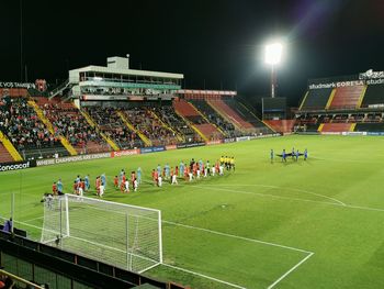 Group of people on soccer field at night