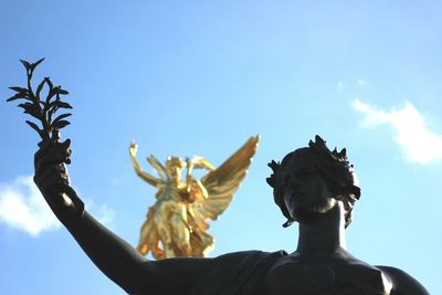 Low angle view of statues against sky