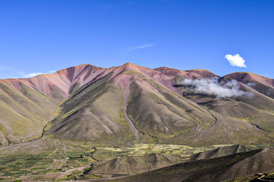 Scenic view of mountain range against blue sky