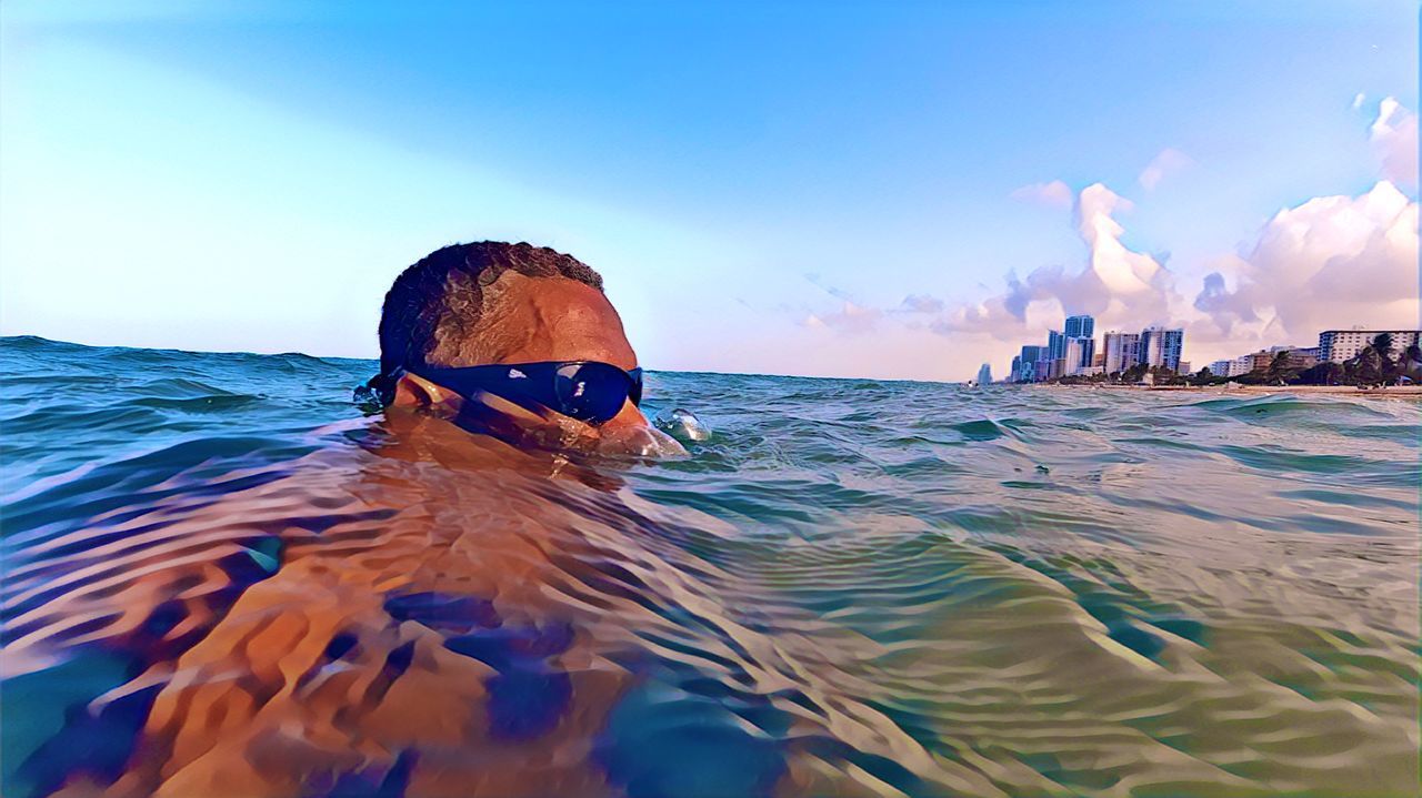 PORTRAIT OF MAN SWIMMING IN POOL