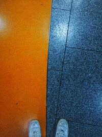 Low section of man standing on tiled floor