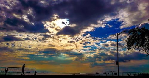 Low angle view of silhouette dramatic sky over sea during sunset