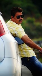 Man wearing sunglasses while sitting in car