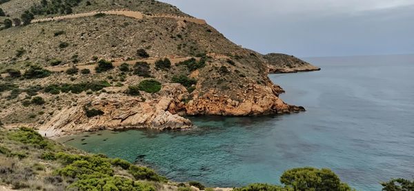 Rock formations by sea against sky