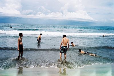 People at beach against sky