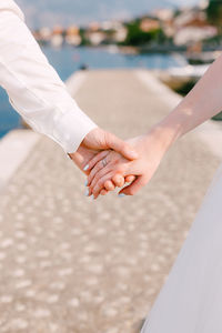 Midsection of couple holding hands
