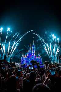 Crowd at music concert against sky at night