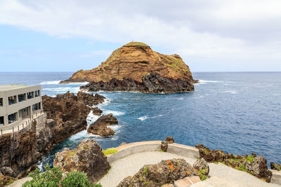 Scenic view of rocks on beach against sky