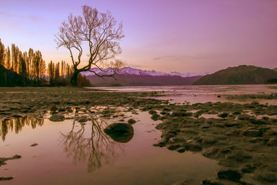 Scenic view of lake against sky at sunset