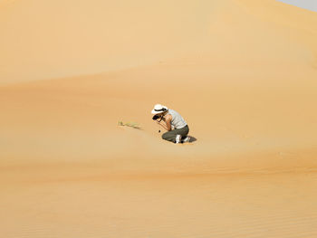 Man on sand dune in desert