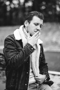 Full length of young man smoking outdoors