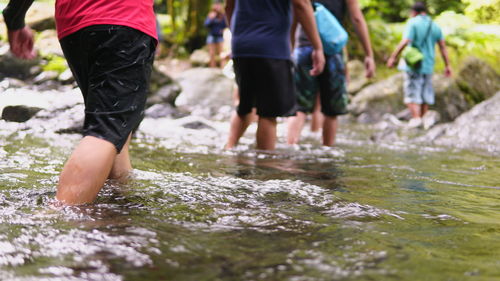 Male friends crossing river
