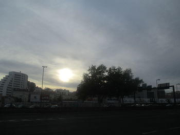 Cars on street in city against sky