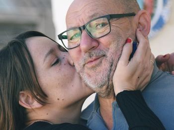 Close-up of daughter kissing father