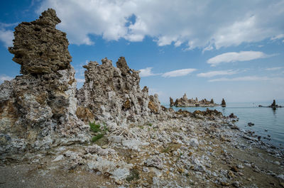 Rock formation on beach against sky