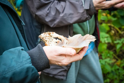Midsection of woman holding a mushroom 