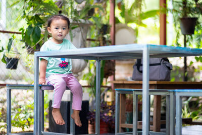 Cute girl sitting on bench in park