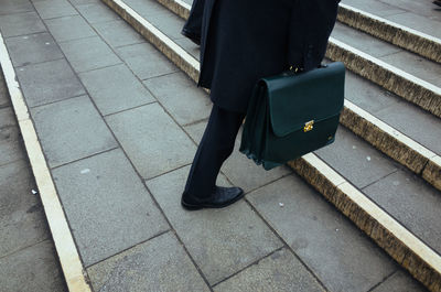 Low section of businessman with briefcase on steps