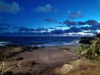 Scenic view of beach against blue sky