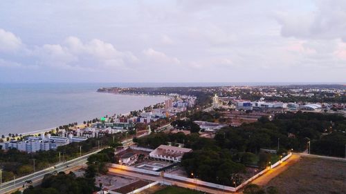 High angle view of cityscape by sea against sky