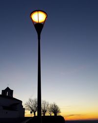 Low angle view of illuminated street light against clear sky