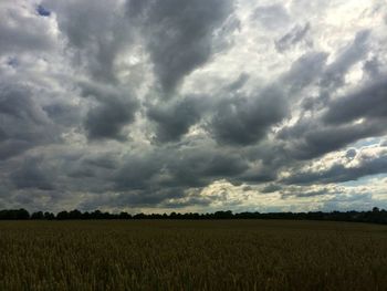 Scenic view of field against cloudy sky