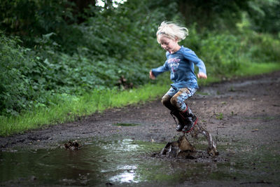 Full length of girl playing in puddle