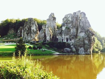Scenic view of lake and rocks against clear sky