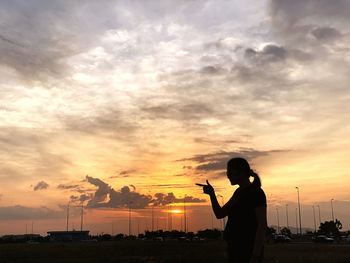 Silhouette man photographing at sunset