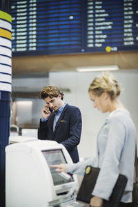 Businesspeople using check in machines at airport