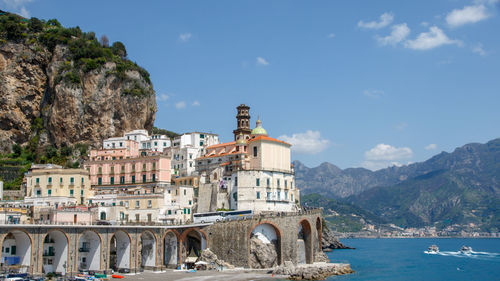 Arch bridge over sea against buildings