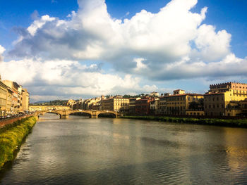 Bridge over river in city against sky