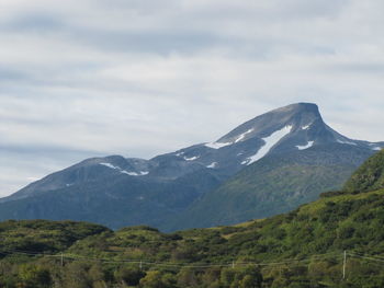 Scenic view of mountains against cloudy sky