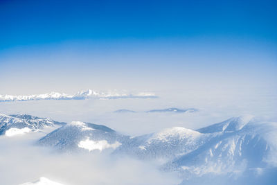 Scenic view of snowcapped mountains against blue sky