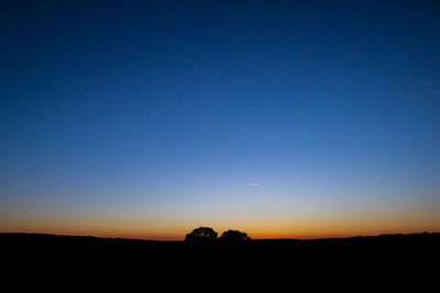 Scenic view of silhouette landscape against clear sky during sunset